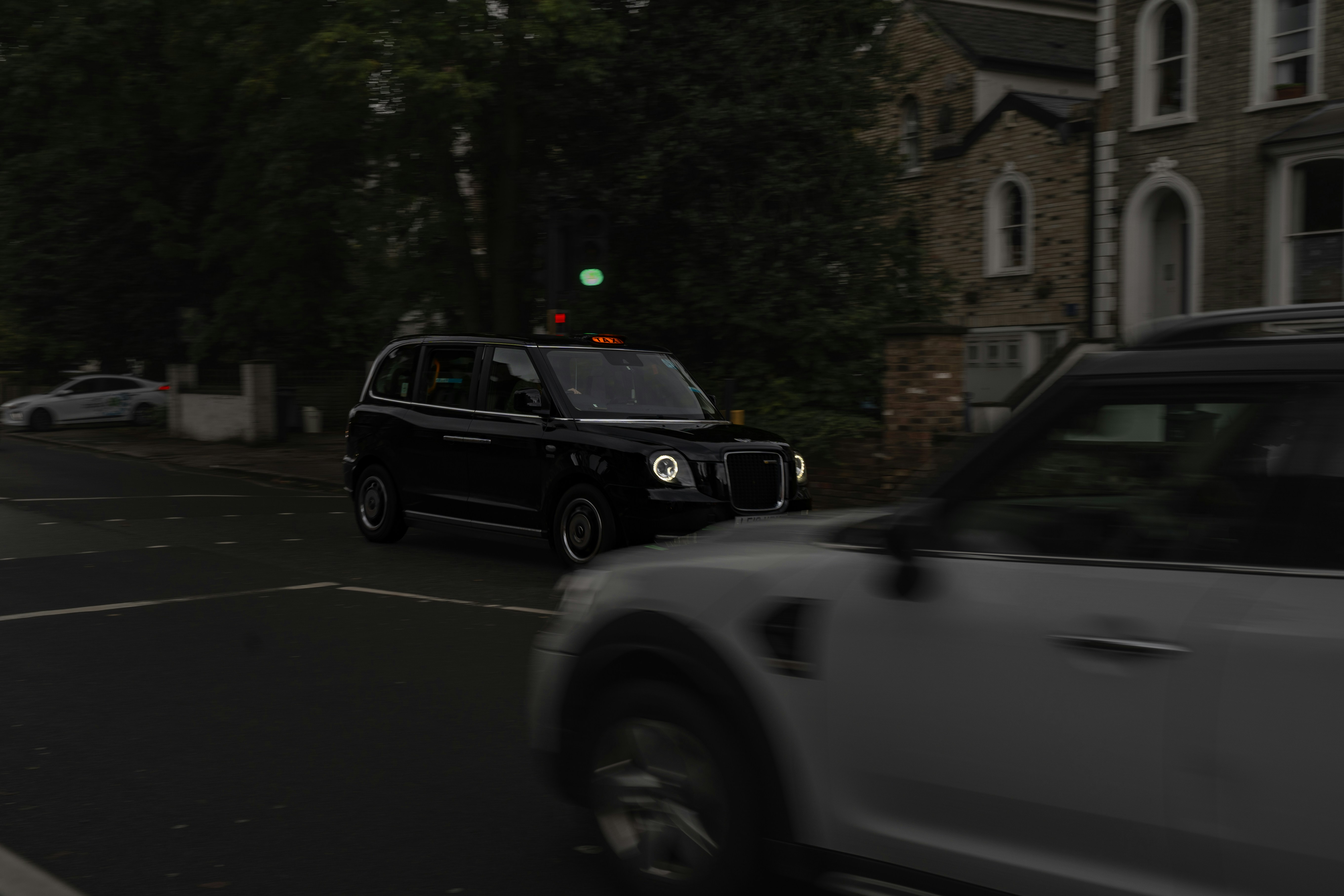 A car driving down a street next to a tall building